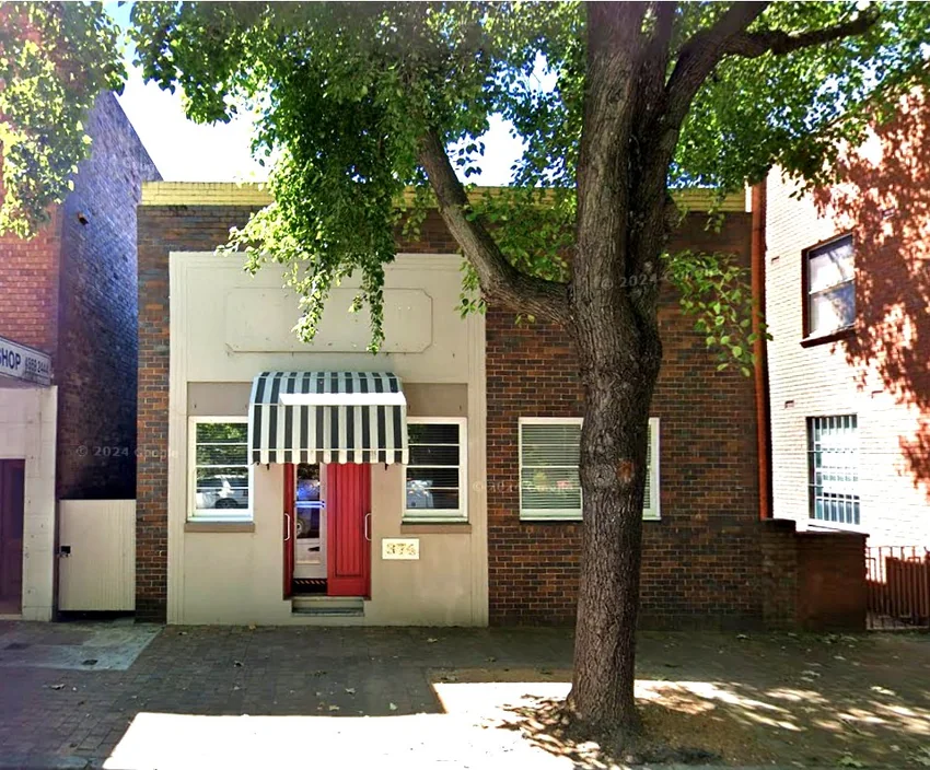 Street frontage of i.care Psychology at 374 Argyle Street, Moss Vale, with red doors and striped awning